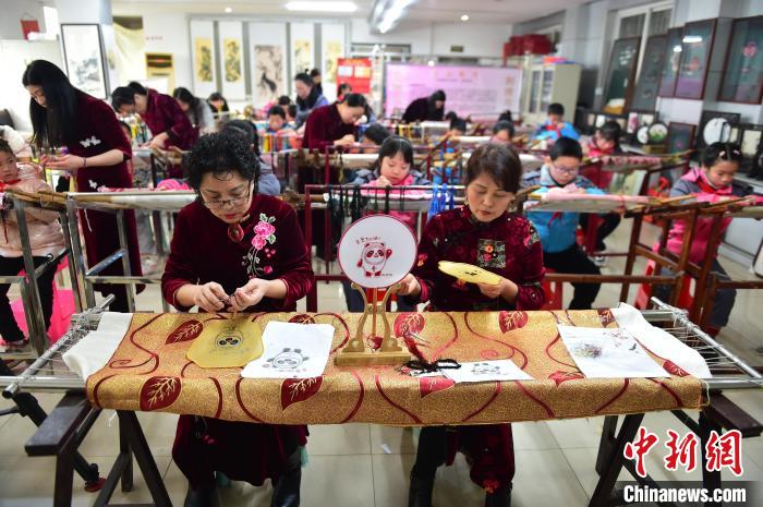 江西省級(jí)非遺豫章繡傳承人手把手指導(dǎo)小學(xué)生繡制2022年北京冬奧會(huì)吉祥物“冰墩墩”形象?！∮髟屏?攝