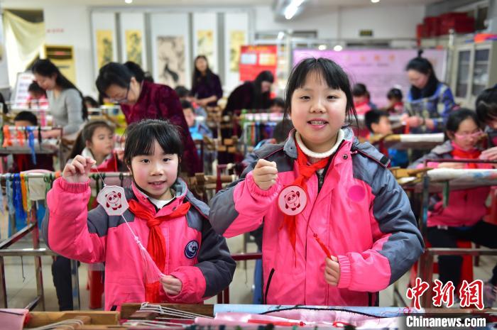 圖為小學(xué)生展示繡制好的2022年北京冬奧會(huì)吉祥物“冰墩墩”形象?！∮髟屏?攝