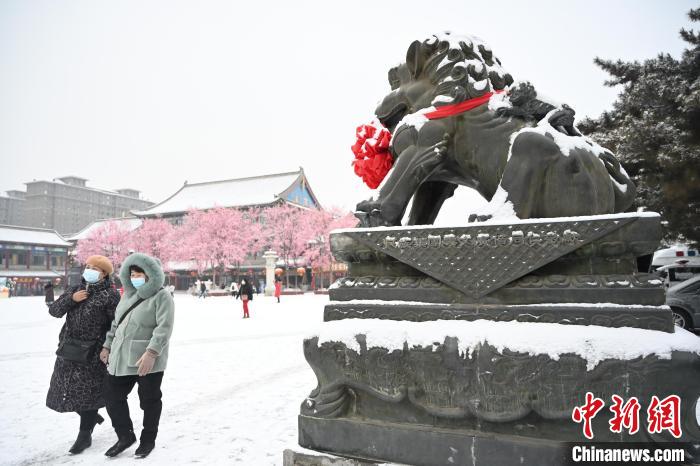 2月13日，民眾在呼和浩特市大召廣場雪中漫步?！⑽娜A 攝