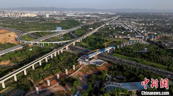 航拍正在建設(shè)的跨越成都繞城高速公路連續(xù)梁施工現(xiàn)場，旁邊依次為已運營的成渝高速鐵路和機場高速公路?！⒅铱?攝
