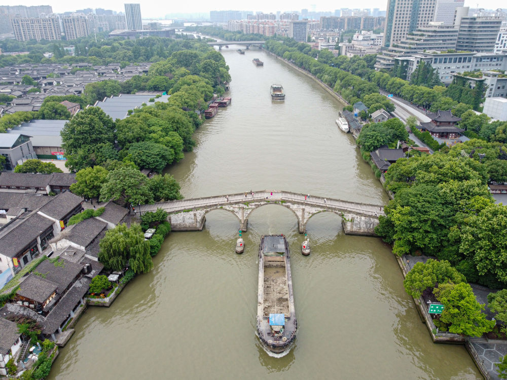 5月27日，一艘貨船駛過京杭大運河南端標志建筑杭州拱宸橋。(無人機照片)新華社記者江漢 攝