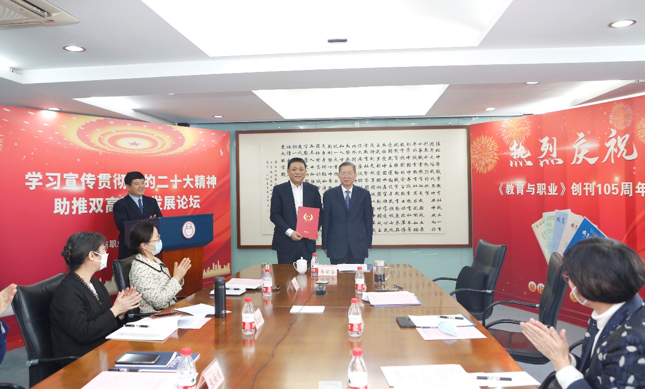 郝明金為《教育與職業(yè)》雜志編委代表陳曉明頒發(fā)聘書。中華職教社供圖