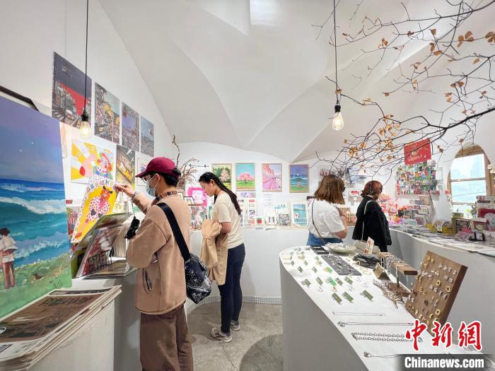 圖為藝術(shù)品商店內(nèi)，顧客挑選插畫作品。　鐘旖 攝