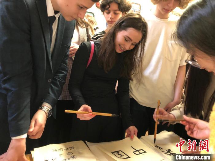 4月21日，莫斯科國立語言大學孔子學院附屬中學舉辦“國際中文日”活動，學生們學寫漢字?！∧箍茋⒄Z言大學孔子學院 供圖