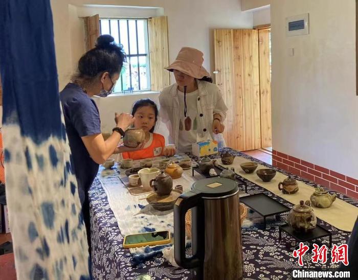 圖為：游客正在咨詢臺灣柴燒作品?！∪~秋云 攝