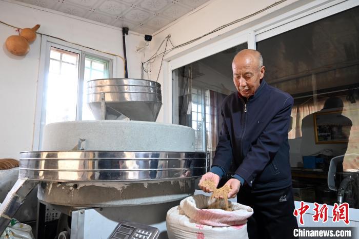 李家莊村民谷文朝重拾父輩的手藝，做起石磨面粉的營生?！〉杂鸺?攝