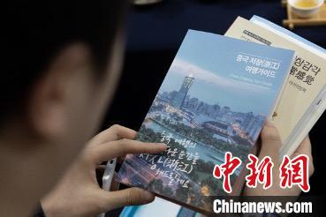 參展觀眾閱讀浙江文旅手冊?！《≌裾?攝