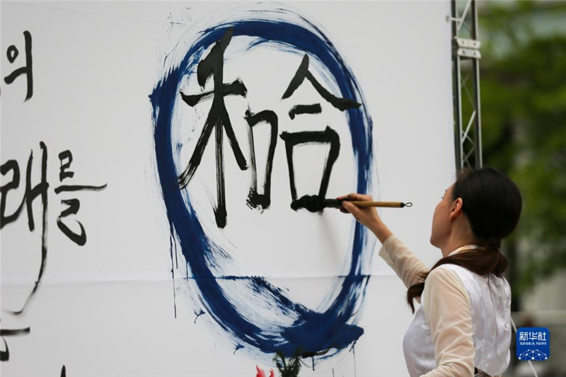 5月30日，在韓國首爾舉辦的“中日韓合作之日”慶?；顒又?，表演者進行中日韓精神——2023年度漢字“和合”書法表演。新華社記者 王益亮 攝