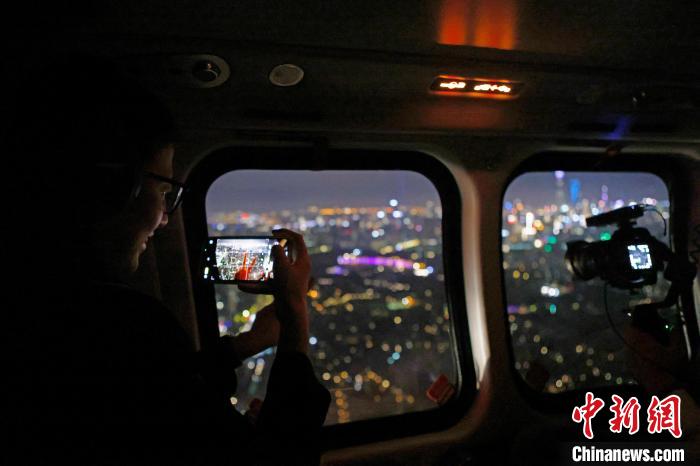 6月3日晚，游客乘坐上海新空直升機有限公司直升機開啟鳥瞰黃浦江空中圓夢之旅，并用手機拍攝城市夜景。　殷立勤 攝
