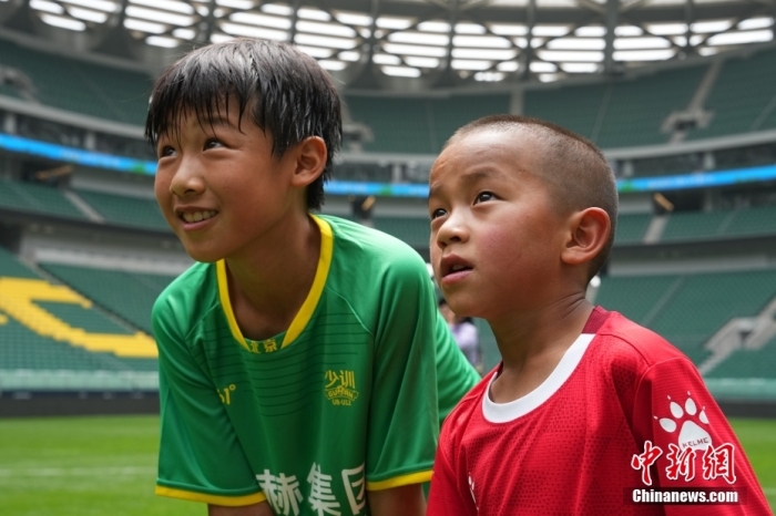 圖為北京國安小球員陳小北和7歲的俄金仁增在一起觀看場內(nèi)播放的紀錄片。<a target='_blank' href='/' _fcksavedurl='/'><p  align=