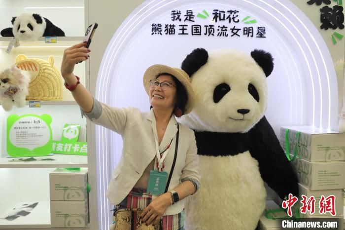 美國華視總裁楊蓮花與大熊貓文創(chuàng)產(chǎn)品合影?！⊥趵?攝