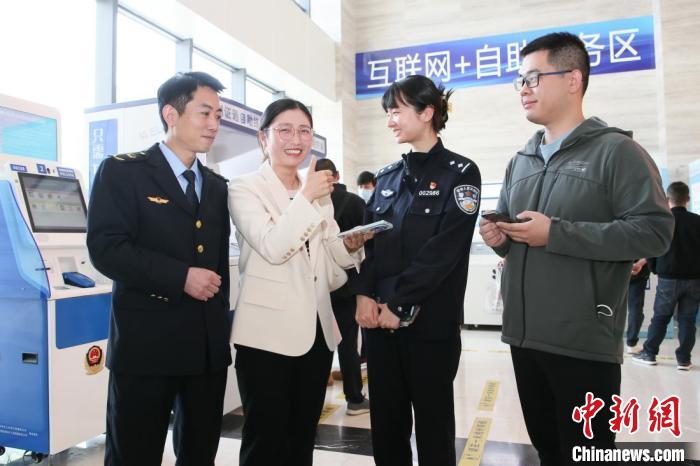 4月10日，安徽合肥，一家運輸企業(yè)負責人在工作人員的指導下，使用小程序辦理車管業(yè)務?！『戏示焦﹫D