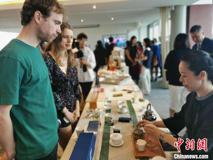 現(xiàn)場觀眾觀看中國展臺茶藝表演、了解茶文化。　靖樹 攝