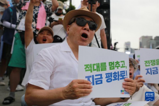 7月22日，在韓國首爾，人們手舉標(biāo)語參與反戰(zhàn)游行。新華社發(fā)（楊暢 攝）