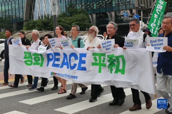 7月22日，在韓國首爾，人們手舉標(biāo)語參與反戰(zhàn)游行。新華社發(fā)（楊暢 攝）