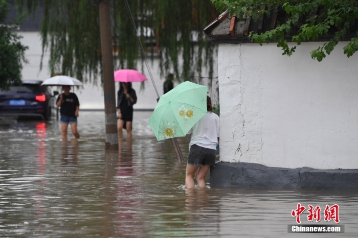7月31日，市民行走在雨中的北京房山區(qū)瓦窯頭村。北京市氣象臺當日10時發(fā)布分區(qū)域暴雨紅色預警信號。北京市水文總站發(fā)布洪水紅色預警，預計當日12時至14時，房山區(qū)大石河流域將出現(xiàn)紅色預警標準洪水。<a target='_blank' href='/'><p  align=