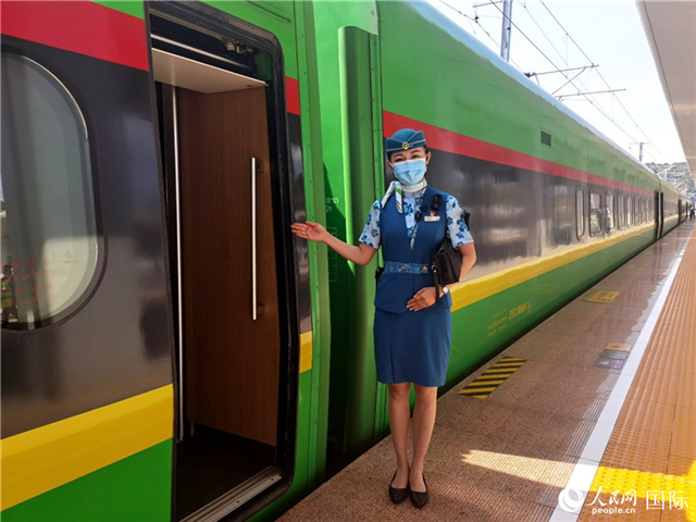 趙瑩靜站在“復(fù)興號”國際旅客列車車廂門口歡迎旅客上車。人民網(wǎng) 杜明明攝
