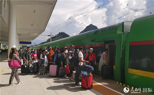 乘坐中老鐵路國際旅客列車的旅客在老撾瑯勃拉邦站排隊上車。人民網(wǎng)記者 杜明明攝