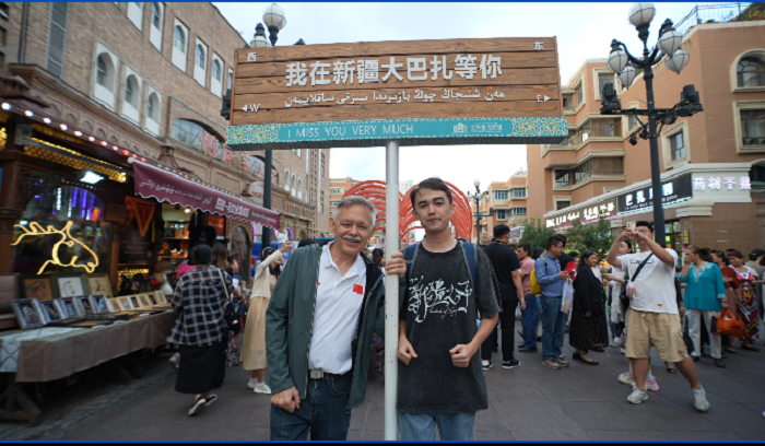 潘維廉和維吾爾族青年伊木蘭“打卡”大巴扎。主辦方供圖