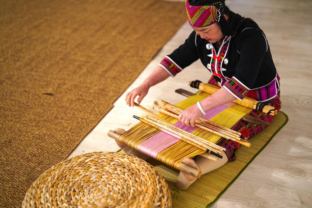 4月17日，黎族傳統(tǒng)紡染織繡技藝國(guó)家級(jí)代表性傳承人劉香蘭在2023年意大利米蘭設(shè)計(jì)周上展示黎錦織造技藝。新華社發(fā)