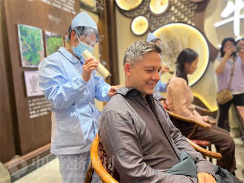  （外媒記者體驗艾灸。中國經(jīng)濟周刊記者 郭志強 攝）