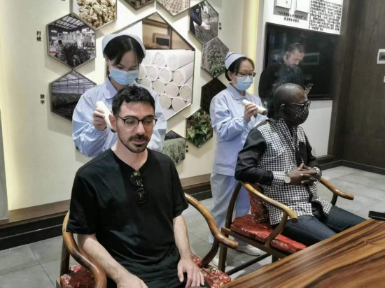 2023“一帶一路”媒體合作論壇聯(lián)合采訪團(tuán)團(tuán)員在九牛草展示館體驗艾灸。（本報記者 黃超攝）