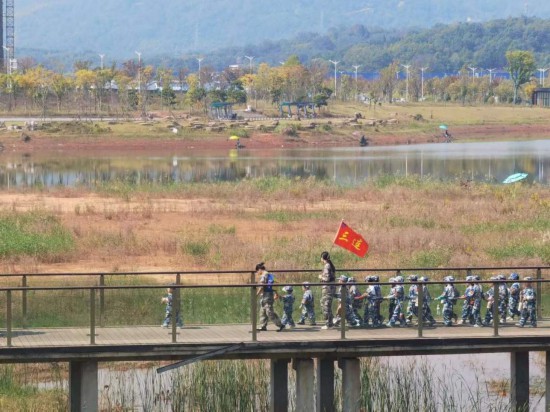 　　10月24日，秋游的幼兒園小朋友在老師帶領(lǐng)下走在清水塘公園里的木橋上。本報(bào)記者 常雯宜攝