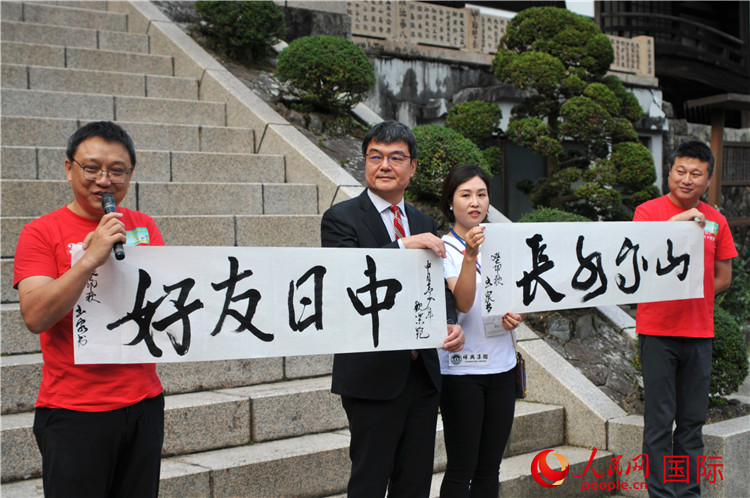東京中國文化中心主任羅玉泉展示其為本次活動書寫的題詞“中日友好，山高水長”。人民網(wǎng) 蔣曉辰攝