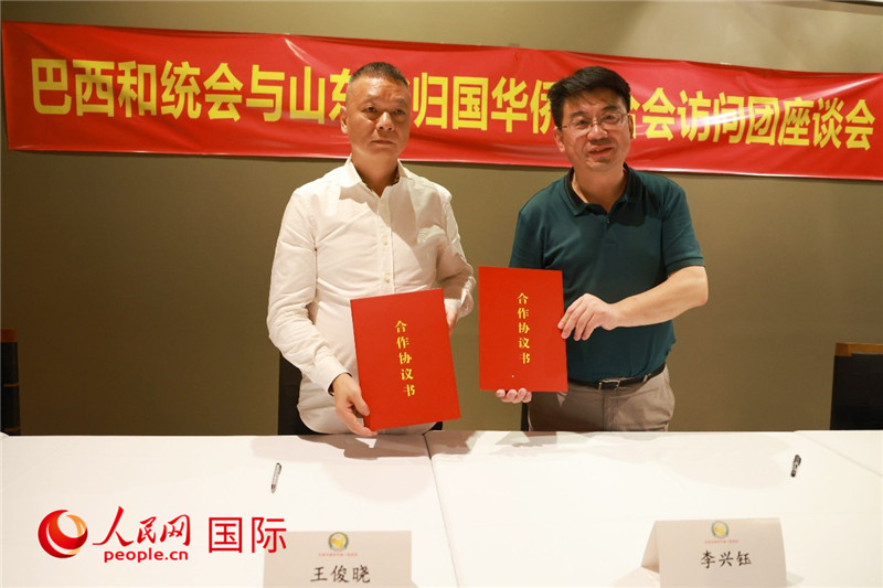 中國僑聯(lián)副主席、山東省僑聯(lián)主席李興鈺（右）與巴西和統(tǒng)會會長王俊曉簽署合作協(xié)議書。人民網(wǎng)記者 陳海琪攝