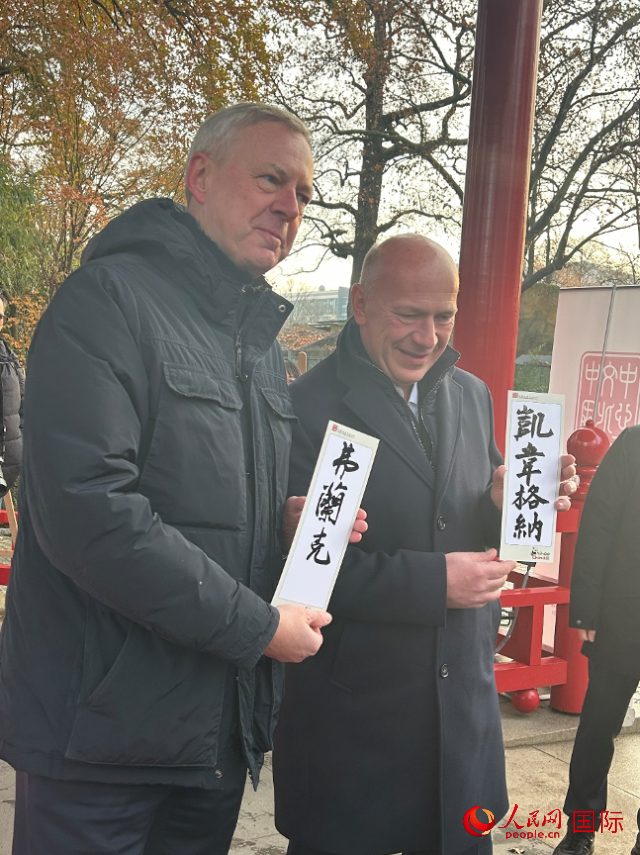 柏林市長(zhǎng)韋格納（右）、動(dòng)物園監(jiān)事會(huì)主席布魯克曼（左）手持中國(guó)文化中心工作人員現(xiàn)場(chǎng)手書(shū)的中文名字。人民網(wǎng)記者 徐馨攝