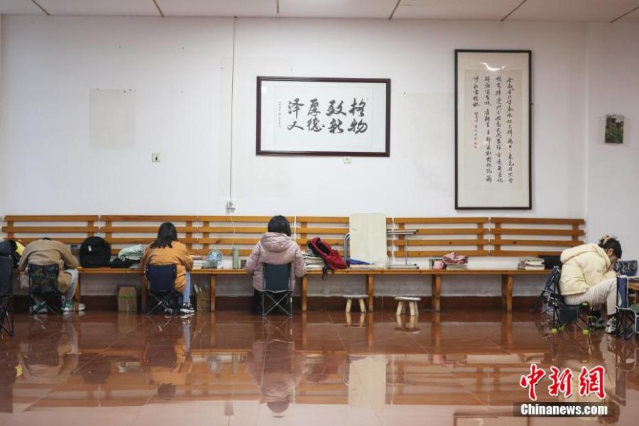 資料圖：幾位考研學(xué)生在南昌大學(xué)教學(xué)樓的公共空間復(fù)習(xí)備考。劉力鑫 攝