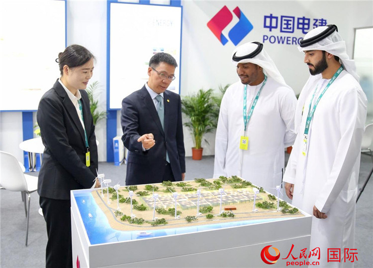 訪客在中國電建展臺參觀風(fēng)電項目沙盤。人民網(wǎng) 塔里克·易卜拉欣攝