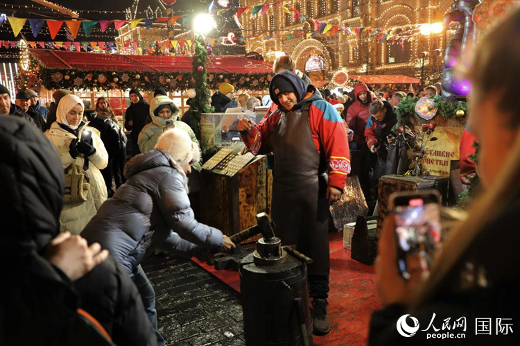 游客在新年集市上體驗制作紀念幣。人民網記者 隋鑫攝