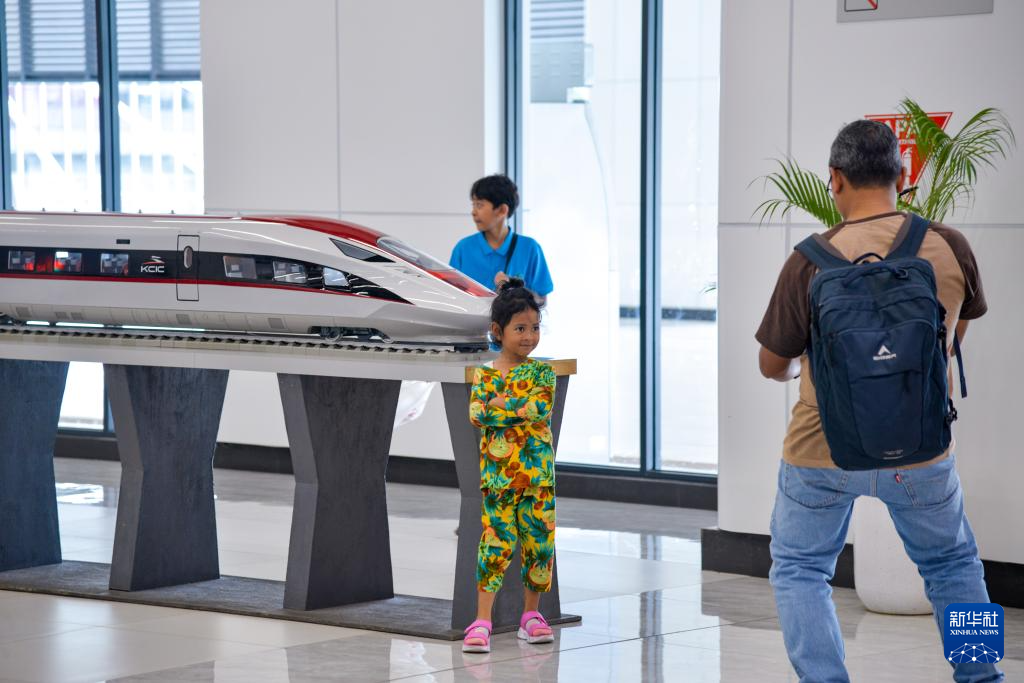 1月24日，在印度尼西亞雅加達(dá)哈利姆站候車大廳，一名小朋友和雅萬高鐵高速動車組模型合影。新華社記者 徐欽 攝