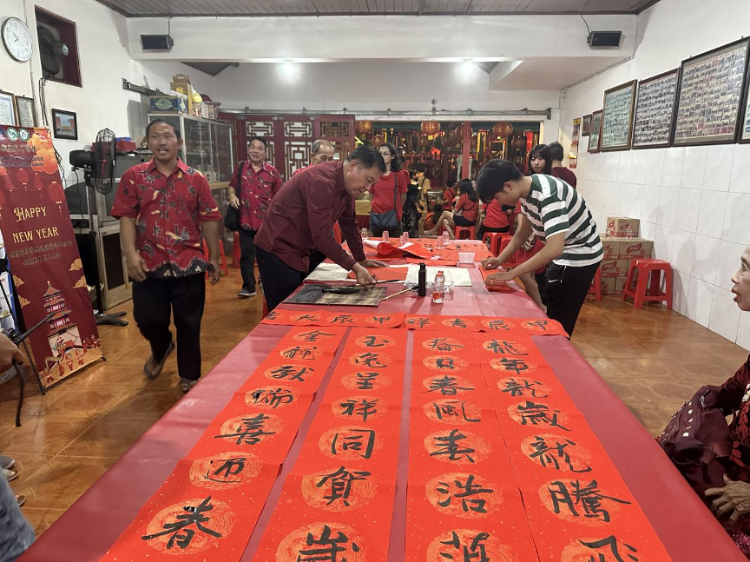 茍皓東為華人朋友現(xiàn)場寫春聯(lián)送福字。巴陵康孔子學(xué)院供圖