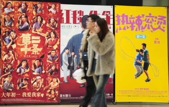 這是2月17日，在沈陽一家影院，觀眾從海報前經(jīng)過。新華社記者李鋼攝