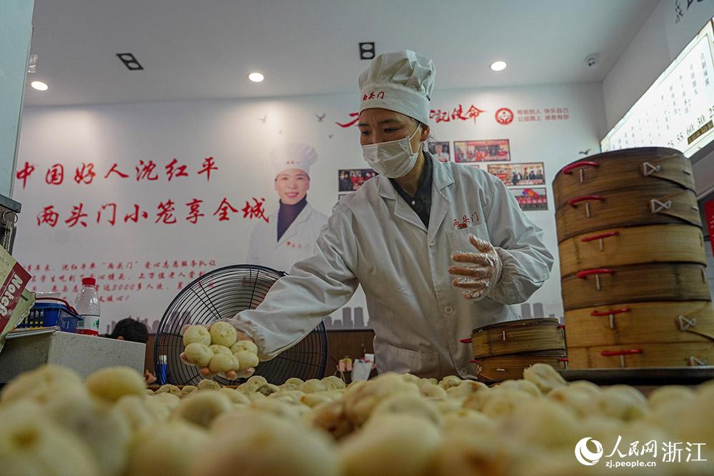 3月31日，在浙江省嵊州市甘霖鎮(zhèn)，嵊州小吃從業(yè)者沈紅平把蒸熟的小籠包晾涼，打包冷藏售賣。人民網(wǎng) 章勇濤攝