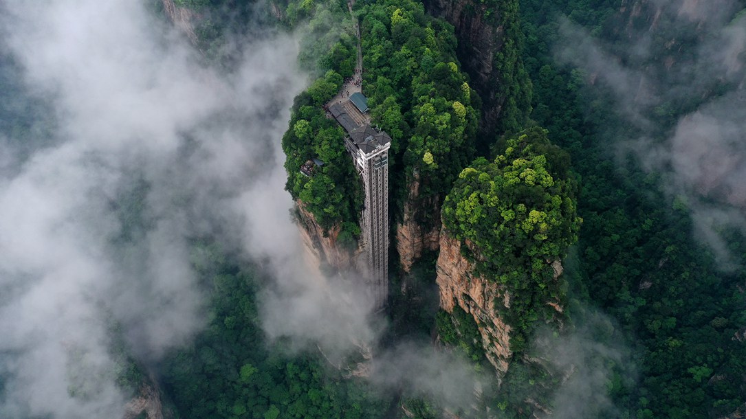 位于張家界武陵源景區(qū)的百龍?zhí)焯蓁偳对谠旗F繚繞的峰林間，雄偉壯觀。吳勇兵攝