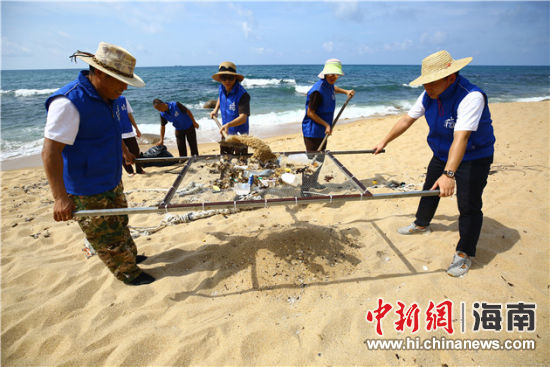 環(huán)保志愿者用篩網(wǎng)“淘”出海灘上的垃圾。