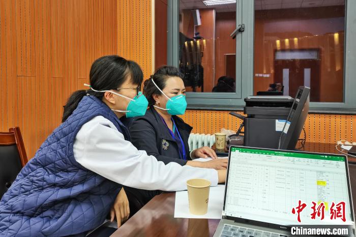 8月9日，楊蘇喬(左)在拉薩方艙醫(yī)院指揮部讀取艙內(nèi)患者胸部CT?！∈茉L(fǎng)者供圖