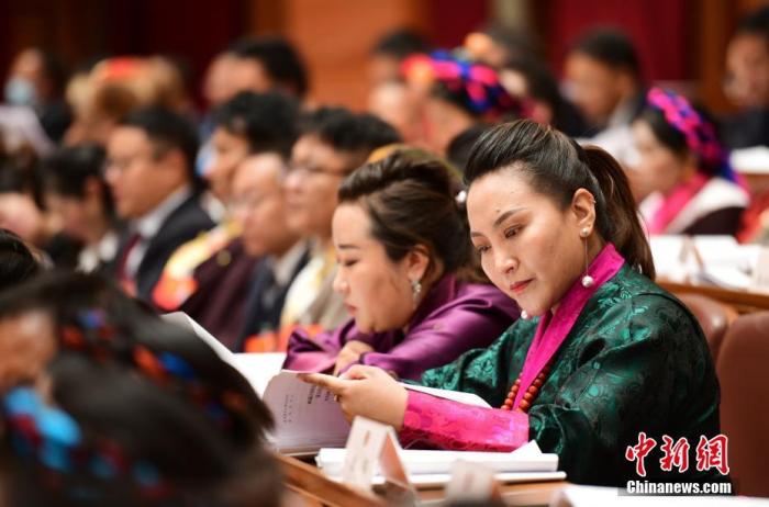 1月5日，次旦卓嘎(右一)在拉薩參加西藏自治區(qū)第十一屆人民代表大會(huì)第五次會(huì)議第二次全體會(huì)議。西藏自治區(qū)人大代表次旦卓嘎來自日喀則市定日縣，定日縣被稱為“洛諧故鄉(xiāng)”，作為西藏民間歌舞，洛諧已被列入中國國家非物質(zhì)文化遺產(chǎn)項(xiàng)目名錄，這是集歌、舞、樂、彈唱于一體的綜合藝術(shù)形式。參加完西藏2022年新年音樂會(huì)的次旦卓嘎告訴記者，每年參加的基層演出可達(dá)80場，“我希望用最純粹的方式，把最好的聲音帶到西藏乃至中國的各個(gè)角落?！?<a target='_blank' href='/'><p  align=