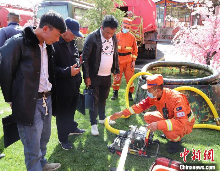 圖為森林消防員為護林員講解滅火裝備的使用方法。　昌都市森林消防支隊 供圖