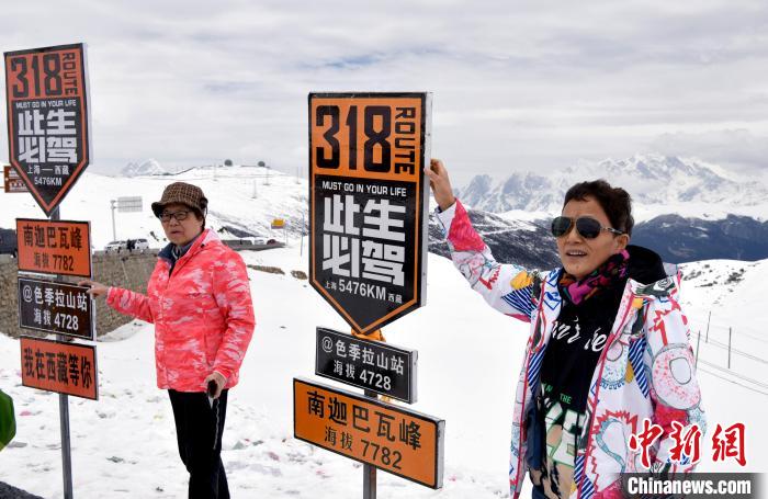圖為5月14日，西藏林芝色季拉山觀景臺，游客與南迦巴瓦峰合影?！±盍?攝