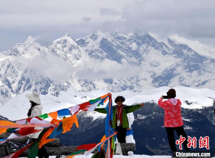 圖為5月14日，西藏林芝色季拉山觀景臺，游客與南迦巴瓦峰合影。　李林 攝