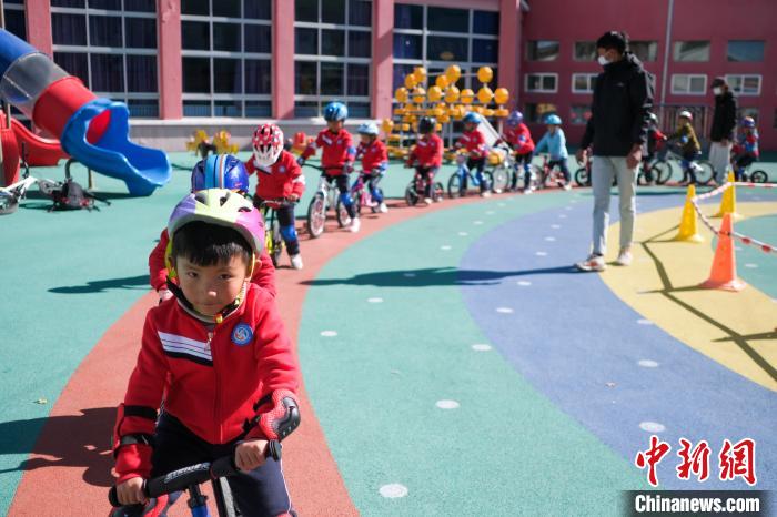 圖為拉薩市實驗幼兒園孩子們在教練的指導(dǎo)下練習(xí)滑步車?！『闻罾?攝