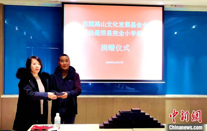 圖為西藏高山文化發(fā)展基金會(huì)理事長溫麗向聶榮縣完全小學(xué)負(fù)責(zé)人捐助儀器?！∮谫e 攝