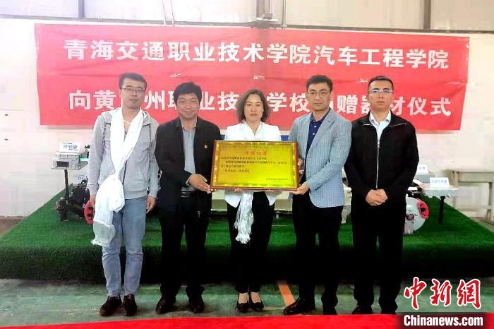 圖為李富香(中)代表學(xué)校為州縣技校捐贈器材。(資料圖) 青海省教育廳供圖