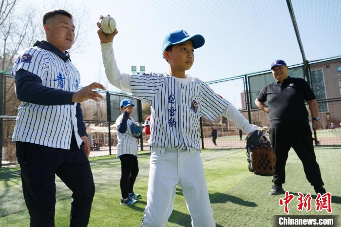 圖為教練指導(dǎo)小棒球手?jǐn)S球技術(shù)?！●R銘言 攝