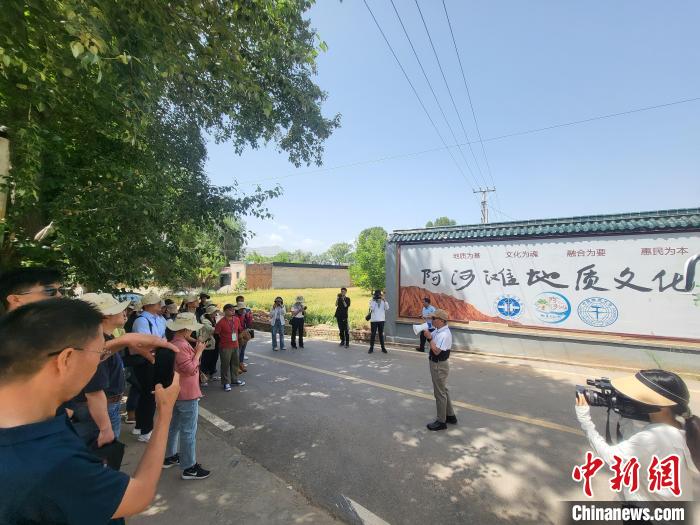 圖為中國地質大學(北京)教授張緒教介紹村落情況。　胡友軍 攝