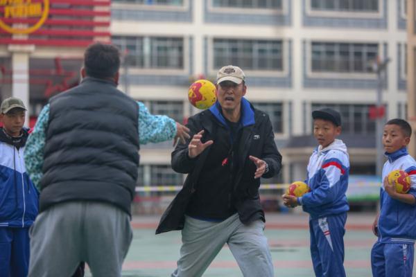 在高原上教孩子們打手球，“慢慢兒來，甭著急！”